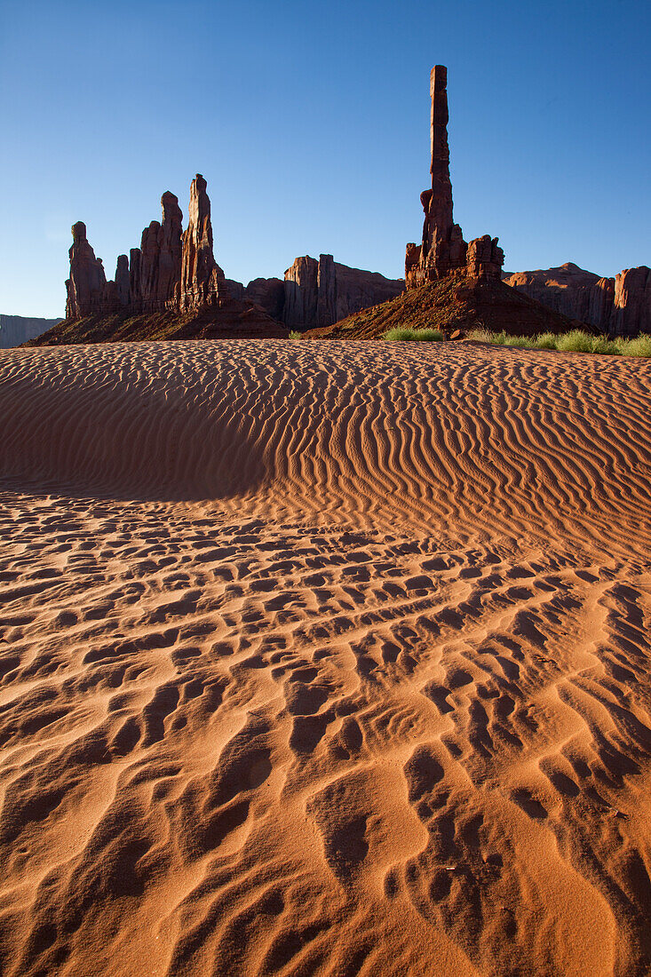 The Totem Pole & Yei Bi Chei with rippled sand in the Monument Valley Navajo Tribal Park in Arizona.