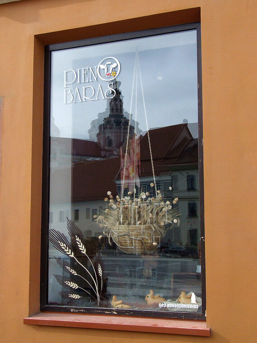 Spiegelung der St. Kasimirkirche in einem Restaurantfenster in der Altstadt von Vilnius, Litauen. Pieno Baras ist litauisch für "Milchbar". Ein UNESCO-Weltkulturerbe