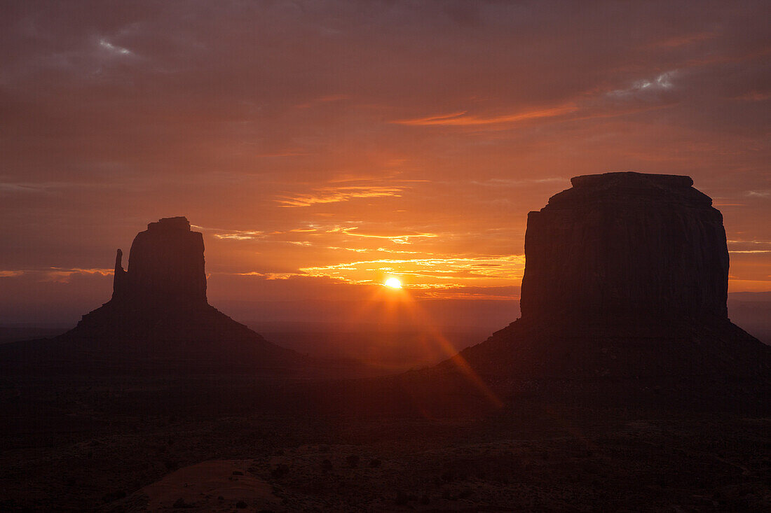 Sonnenaufgang zwischen dem East Mitten & Merrick Butte im Monument Valley Navajo Tribal Park in Arizona