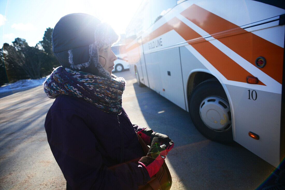 Junge Frau wartet auf den Bus im Bahnhof von Rovaniemi, Lappland