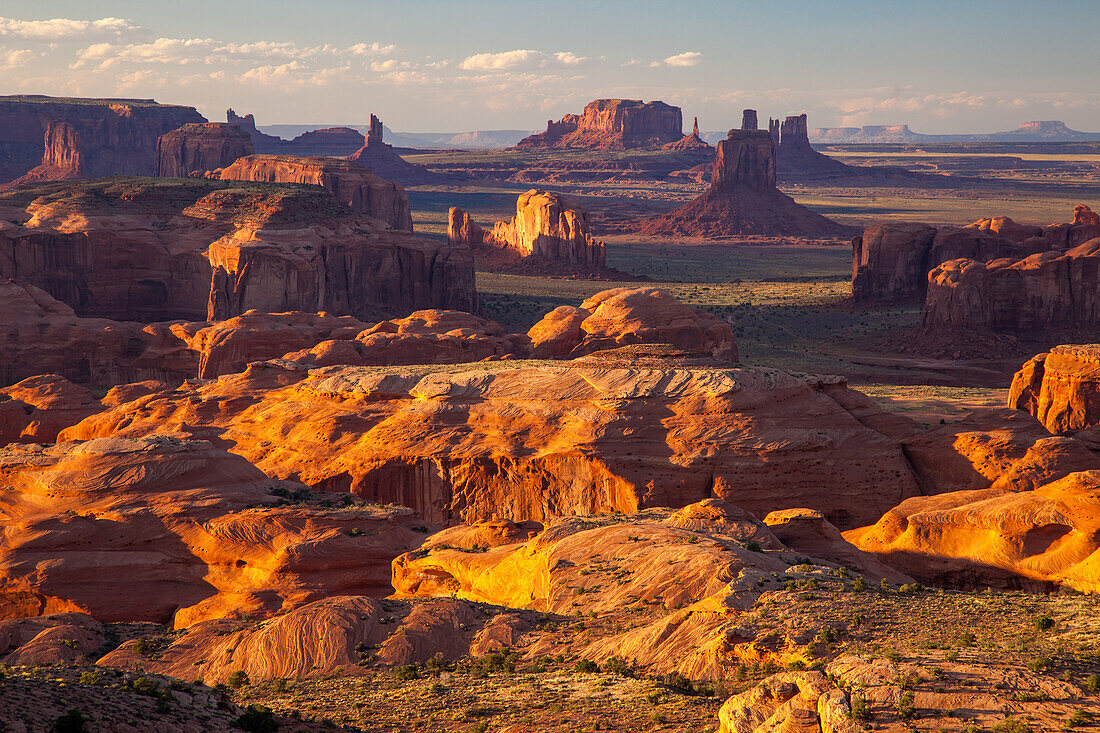 Sonnenuntergangslicht auf den Sandsteinformationen im Monument Navajo Valley Tribal Park in Arizona. Blick von Hunt's Mesa. Die Abajo Mountains und die Bear's Ears, links, in der Ferne