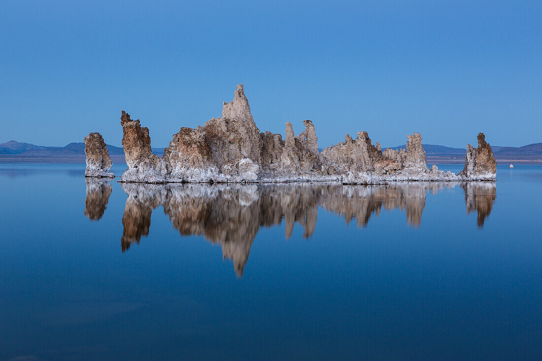 Tufa formations reflected in Mono Lake in California in evening twilight.