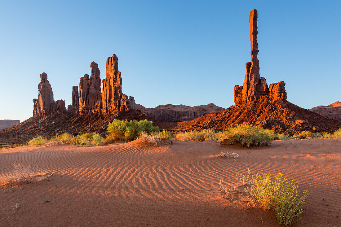 The Totem Pole & Yei Bi Chei with rippled sand dunes in the Monument Valley Navajo Tribal Park in Arizona.