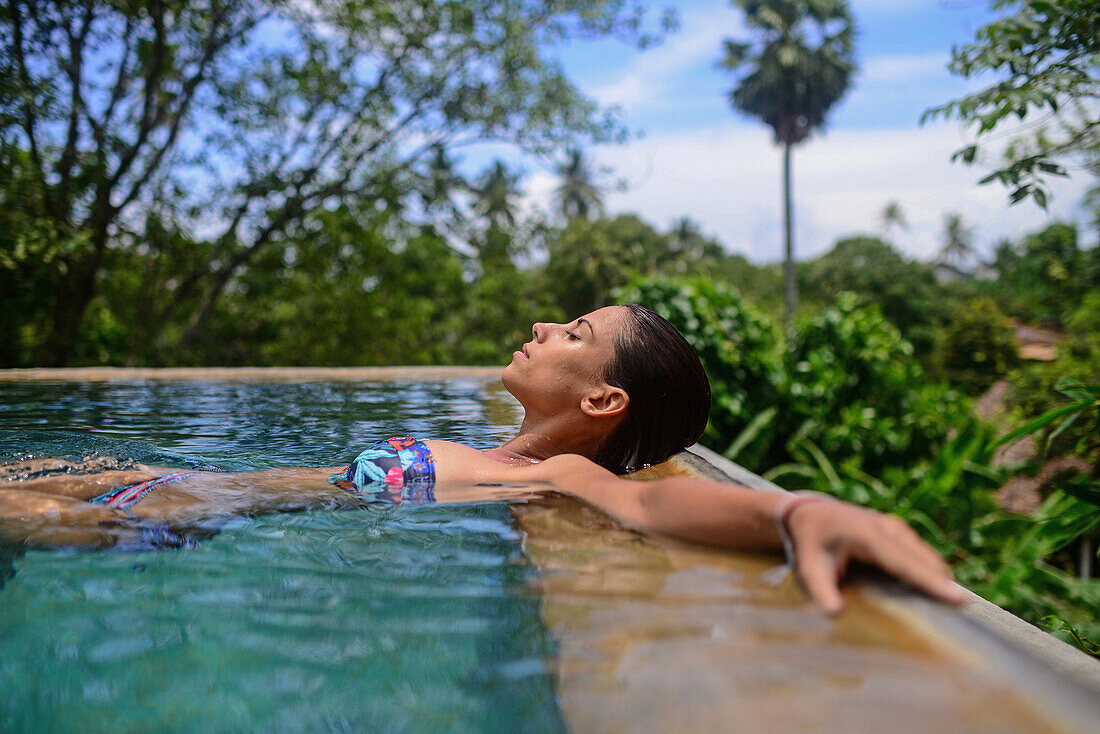 Junge attraktive Frau genießt ein Bad im Infinity-Swimmingpool des The Dutch House, Galle, Sri Lanka