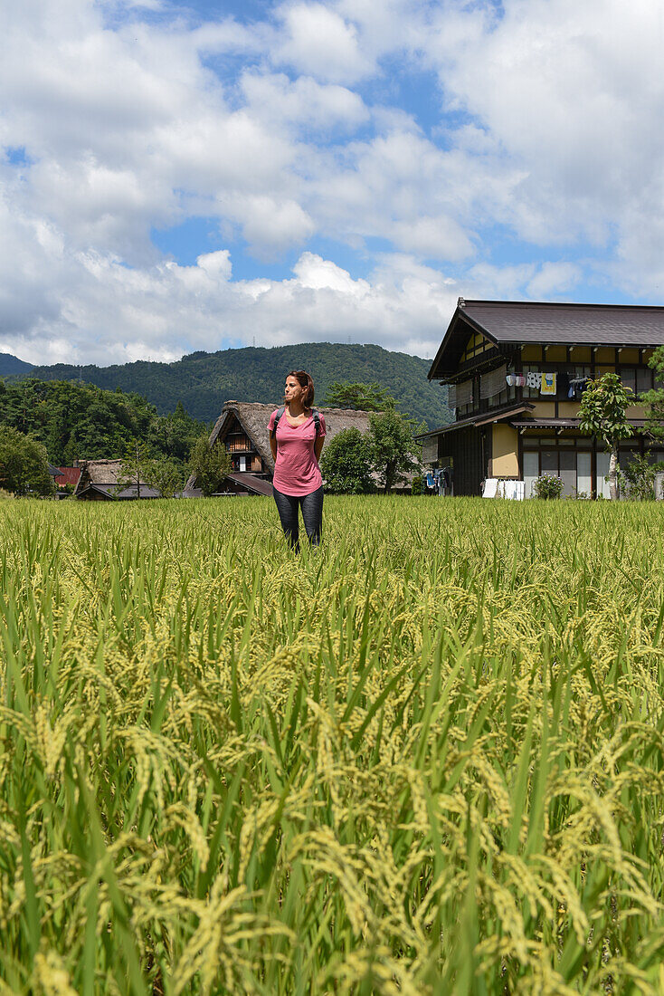 Portrait of a young caucasian woman outdoors in Shirakawa-go, traditional village showcasing a building style known as gassho-zukuri, Gifu Prefecture, Japan