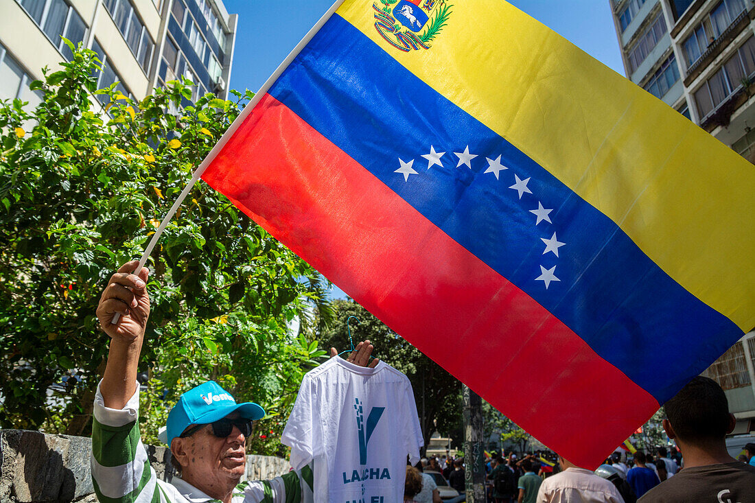 An opponent with the Venezuelan flag and a cap of Maria Corina Machado's Vente party. Rally of the candidate Maria Corina Machado, Venezuelan opposition leader, at Plaza Francia de Altamira in Caracas, on January 23, 2024.