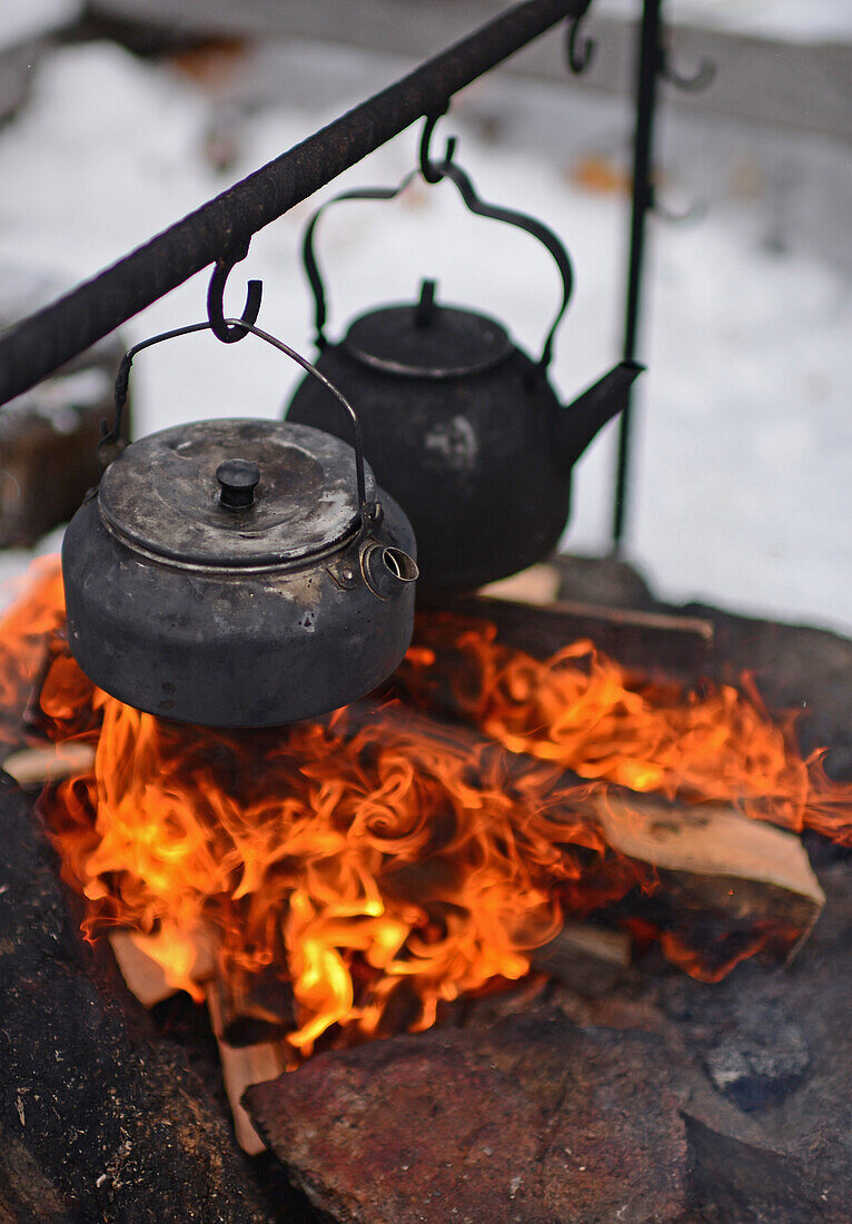 Preparing coffee and tea on the fire at Lake Inari, Lapland, Finland