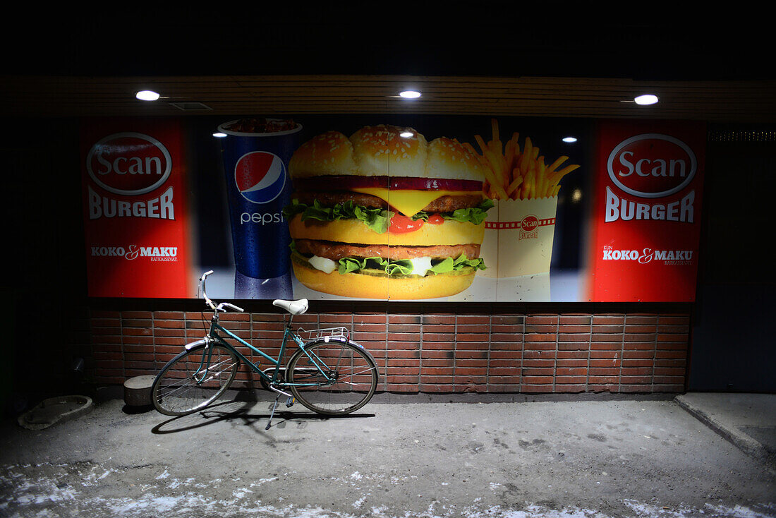 Bike parked by burger restaurant at night, Rovaniemi