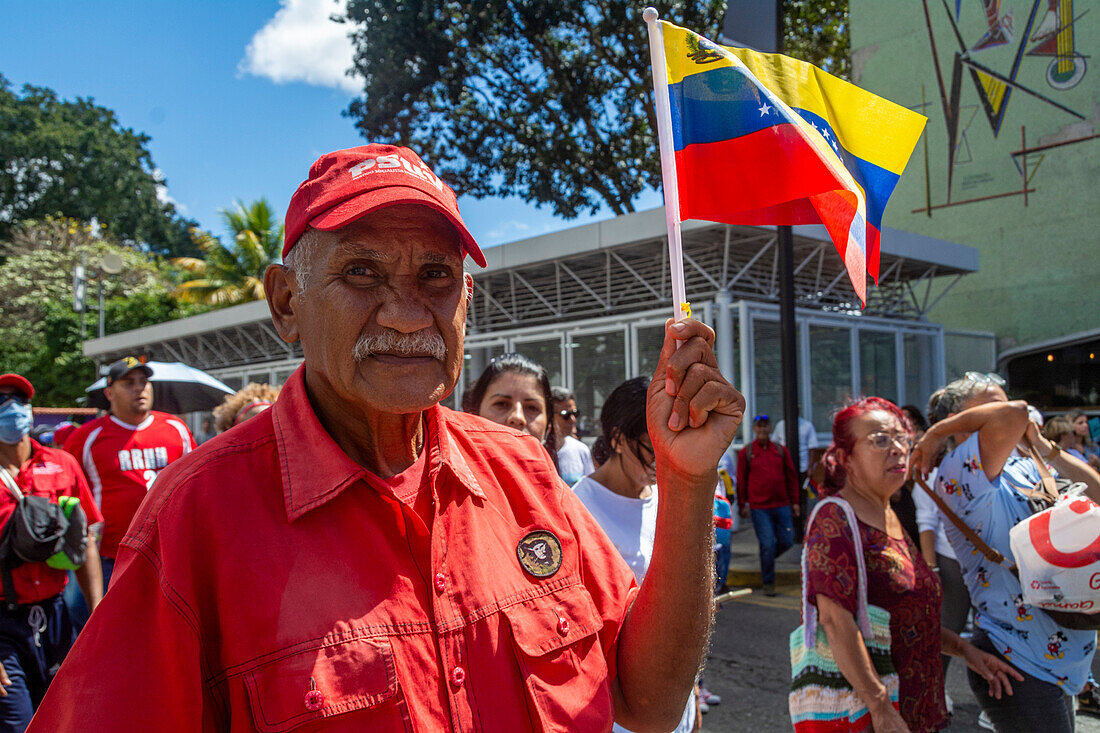 Ein Mann, der die venezolanische Regierung angreift, marschiert durch die Straßen von Caracas, wo die Regierung von Nicolas Maduro am 23. Januar eine Kundgebung abhält