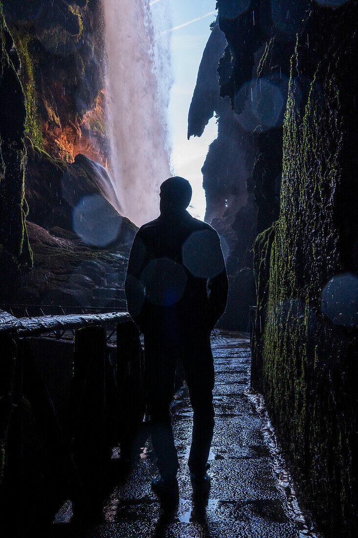 Junger Mann in einer Höhle im Naturpark Monasterio de Piedra, der sich um das Monasterio de Piedra (Steinkloster) in Nuevalos, Zaragoza, Spanien, erstreckt