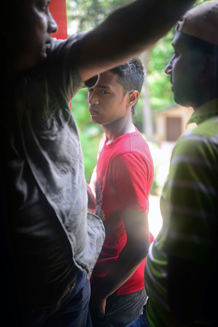 Travellers stand by train door, Sri Lanka