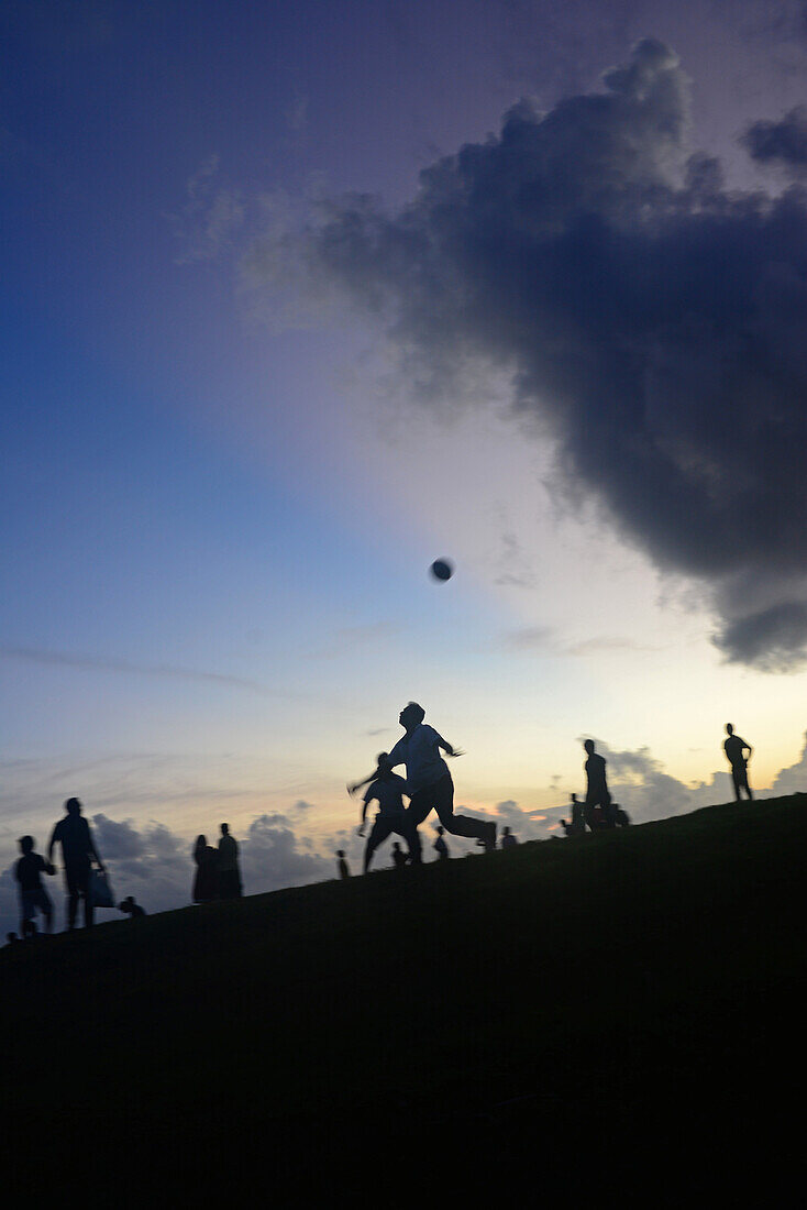 Eine Gruppe von Freunden spielt Fußball bei Sonnenuntergang im UNESCO-Weltkulturerbe Galle Fort, während des Binara-Vollmond-Poya-Tages
