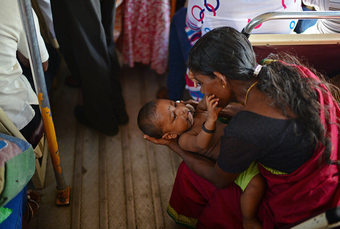 Eine Mutter beruhigt ein Baby in einem öffentlichen Bus, Sri Lanka