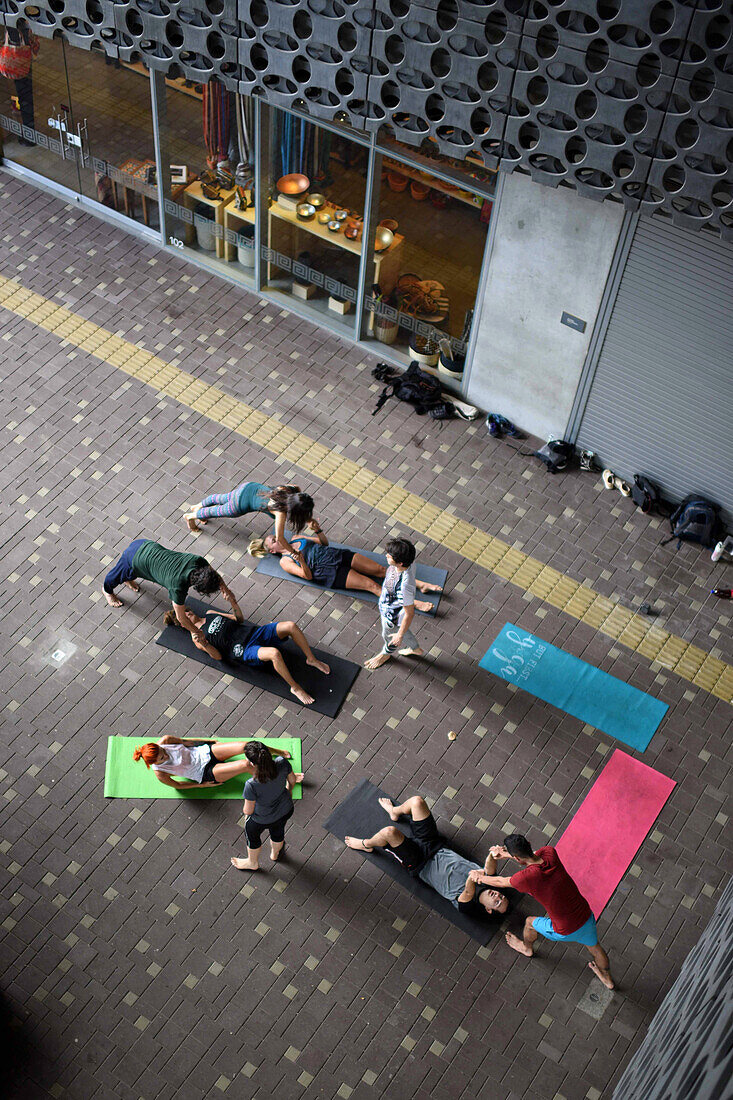 Eine Gruppe von Menschen praktiziert Acroyoga vor dem Museum für moderne Kunst in Medellin (MAMM), Kolumbien
