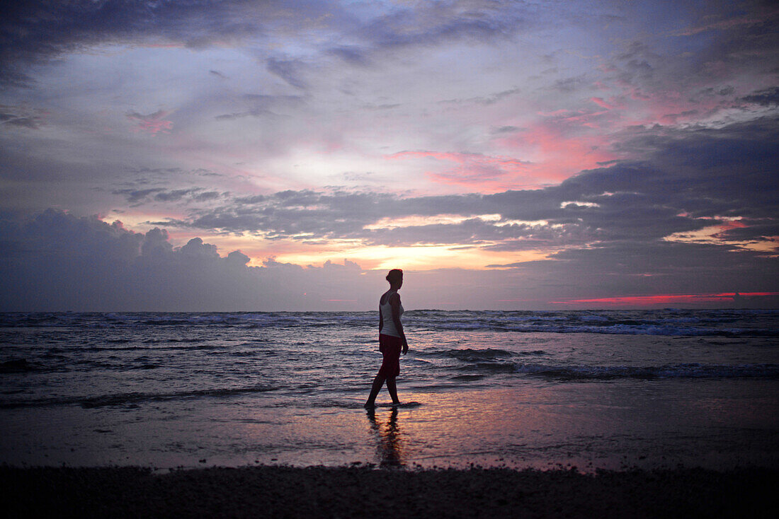 Young woman enjoying sunset at Hikkaduwa beach, Sri Lanka