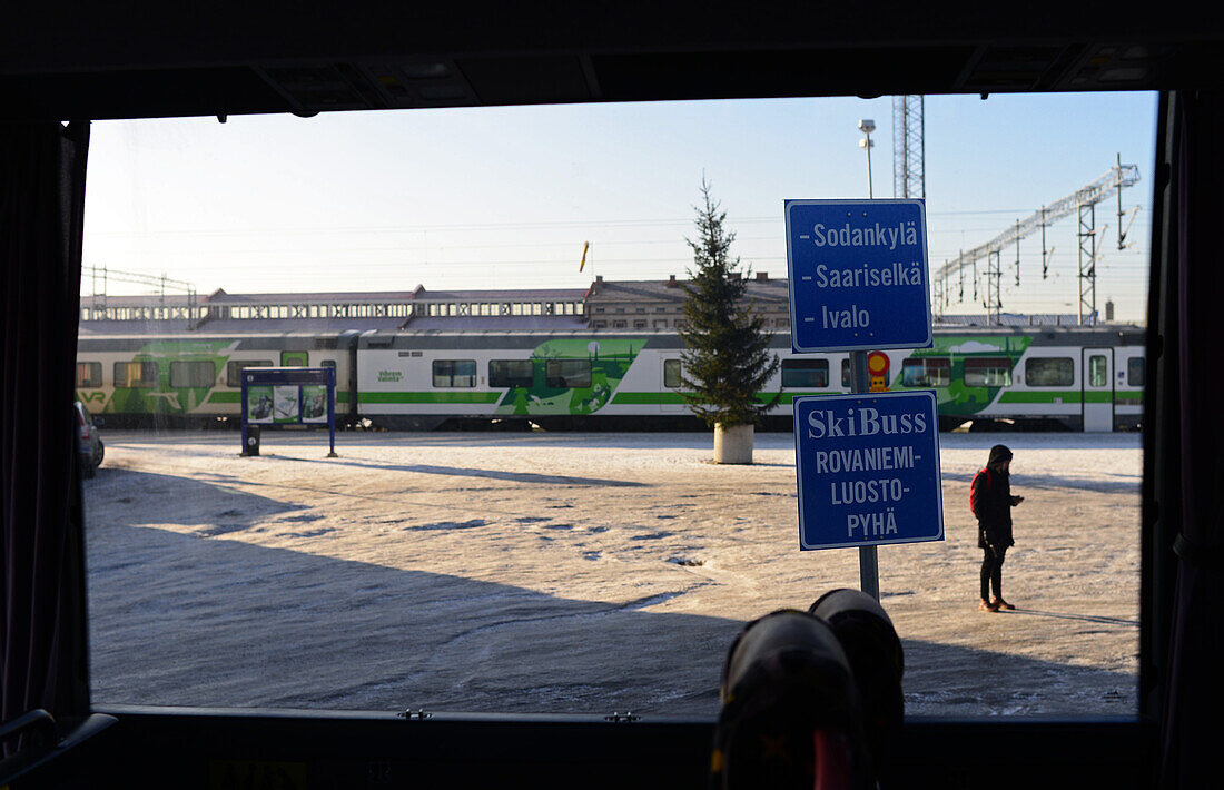 Junge Frau wartet an der Haltestelle auf den Bus