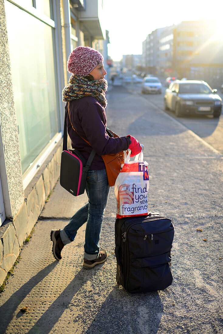 Junge Frau mit ihrem Gepäck auf der Straße