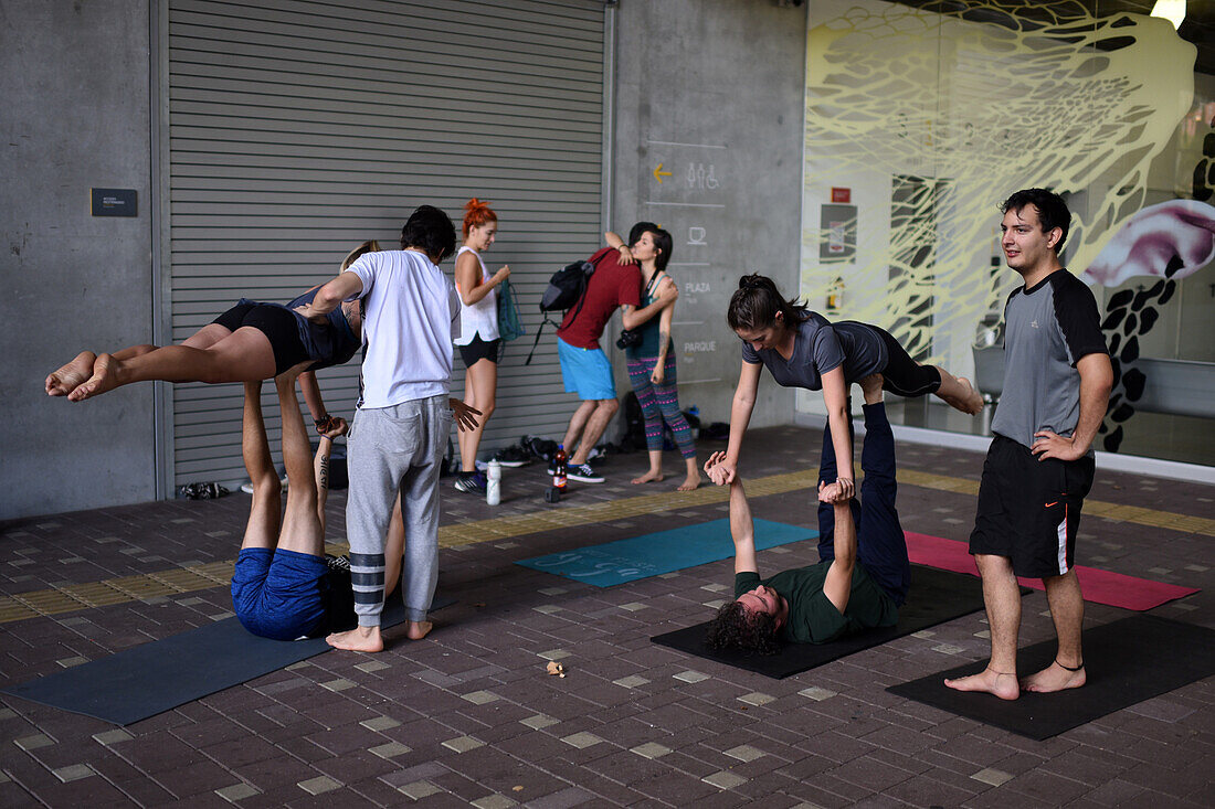 Group of people practice acroyoga outside the Museum of Modern Art of Medellin (MAMM), Colombia