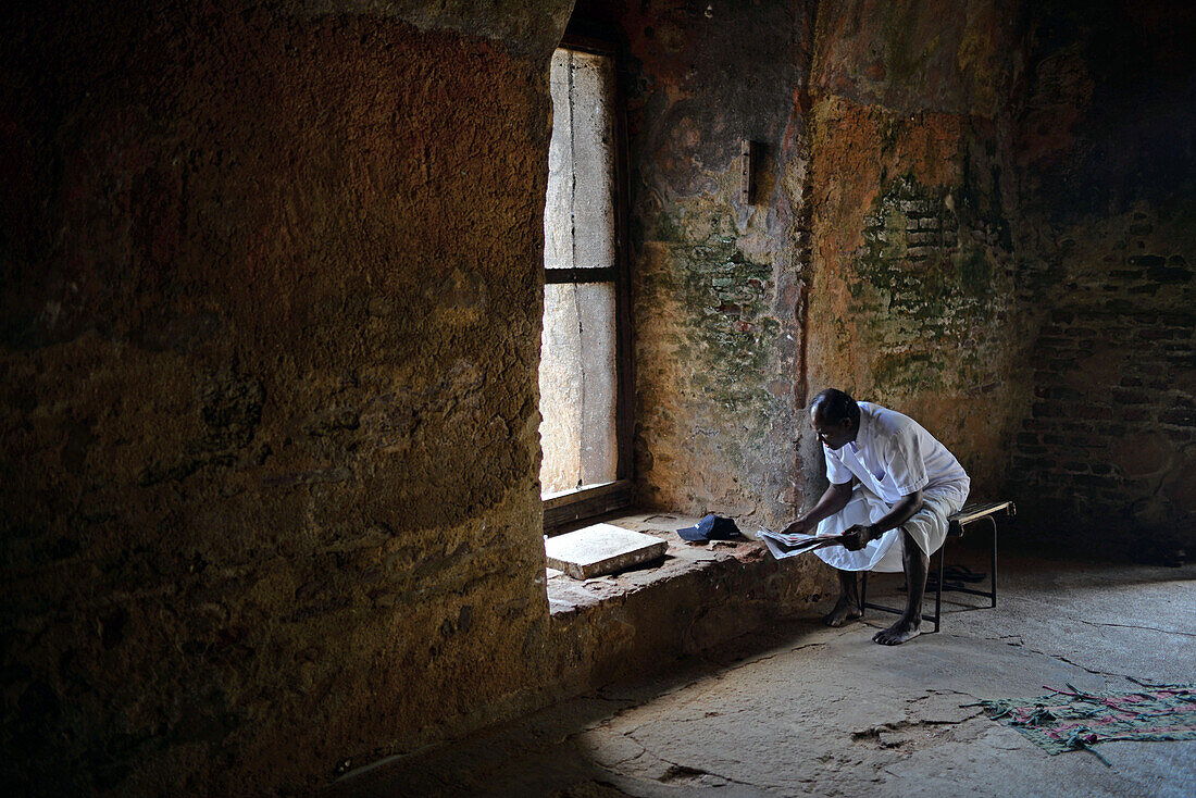 Man reading inside Thuparama at The Ancient City of Polonnaruwa, Sri Lanka