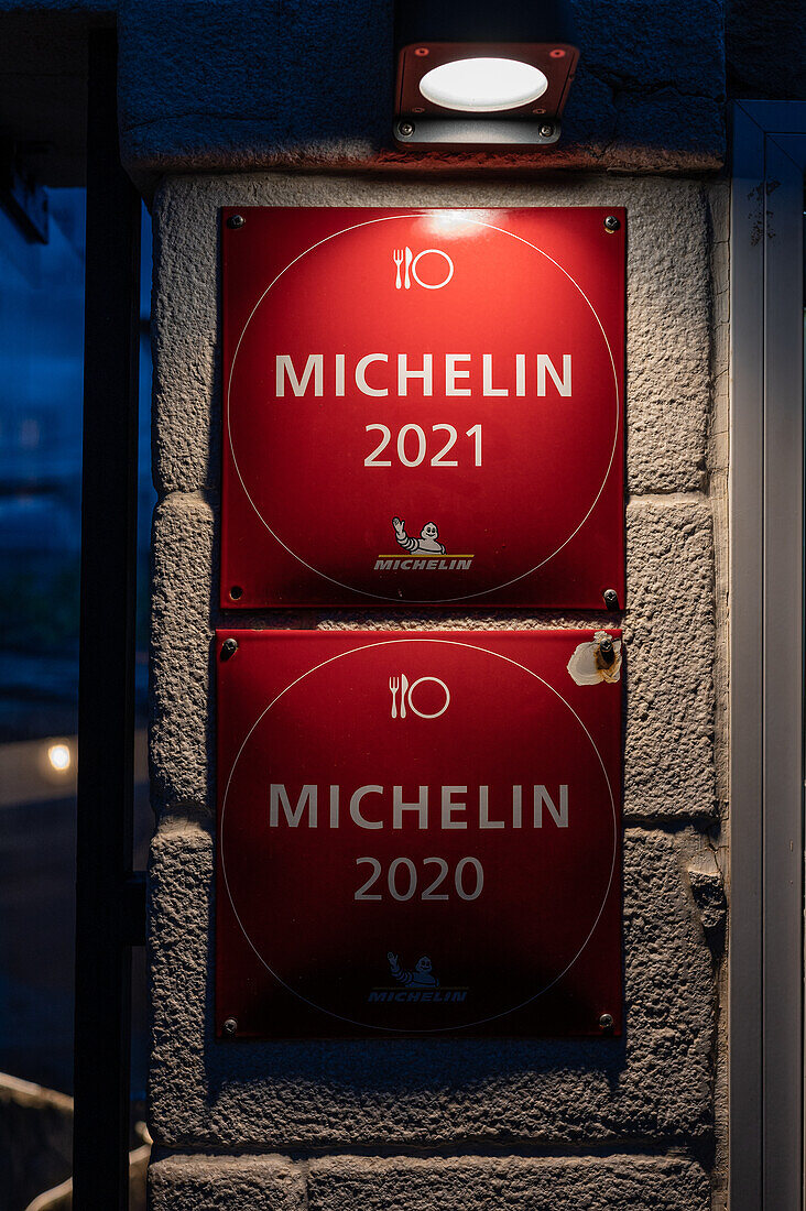 Michelin-Führer-Plaketten am Eingang eines Restaurants Freie Hühner im Hinterhof eines Hauses, Spanien