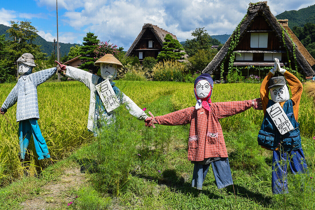 Scarecrows in front of traditional Gassho-Zukuri thatched wooden farmhouses in Shirakawa-go village, Gifu Prefecture, Japan