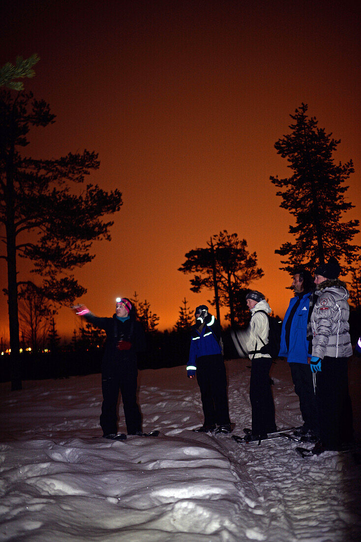 Snowshoeing at sunset through wilderness of Rovaniemi, with Safartica.