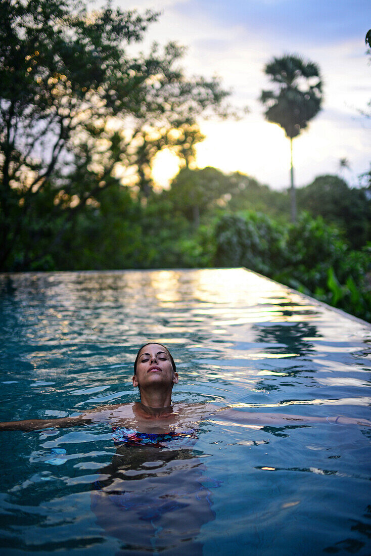 Junge attraktive Frau genießt ein Bad im Infinity-Swimmingpool des The Dutch House, Galle, Sri Lanka