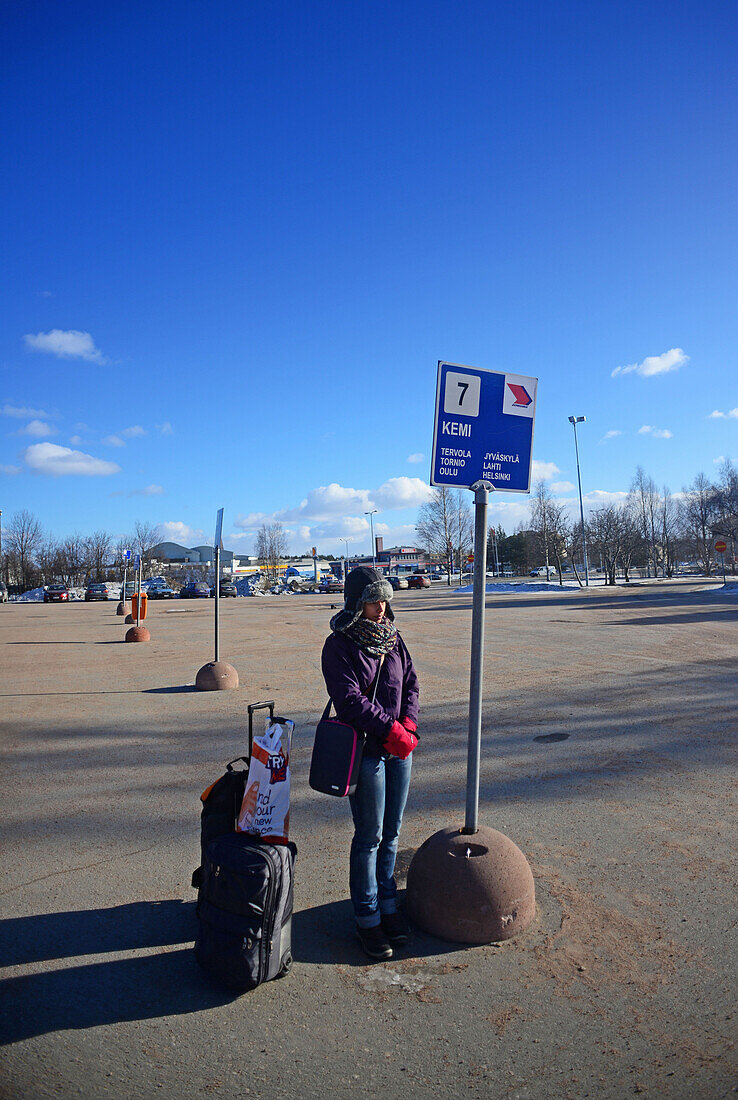Junge Frau wartet auf den Bus im Bahnhof von Rovaniemi, Lappland