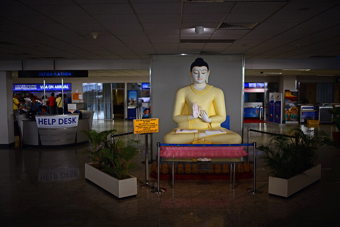 Buddha sculpture and help desk at arrivals hall in Colombo airport, Sri Lanka