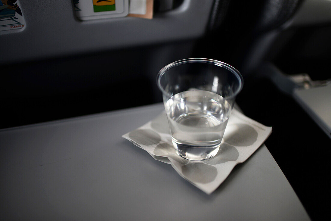 Wasserglas auf dem Tisch eines Flugzeugs