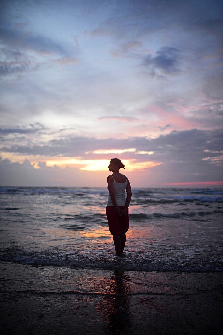 Young woman enjoying sunset at Hikkaduwa beach, Sri Lanka