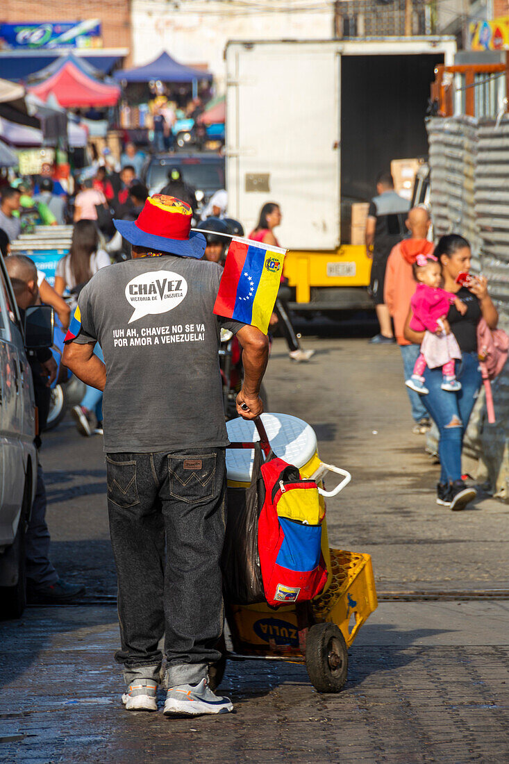 Ein Saftverkäufer trägt ein Hemd mit der Aufschrift "Uh Ah Chavez is not leaving out of love for Venezuela" zum Gedenken an den verstorbenen Präsidenten Hugo Chavez Frias auf einer Straße im beliebten Stadtteil Catia in Caracas, Venezuela