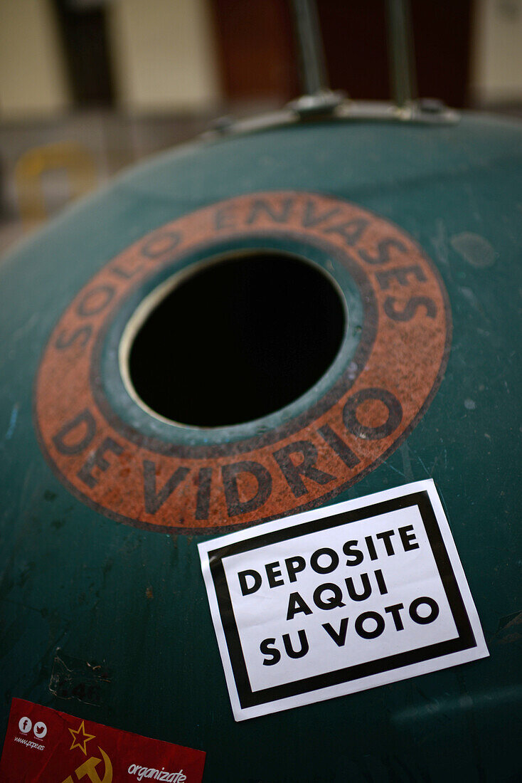 Sticker reads "Deposit your vote here" on recycle trash.