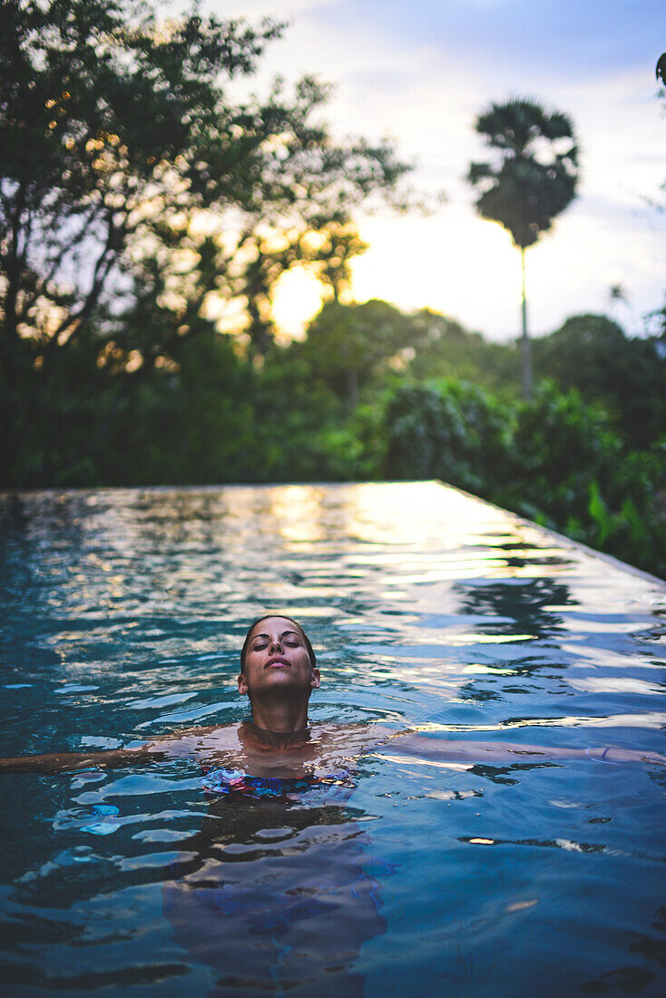 Junge attraktive Frau genießt ein Bad im Infinity-Swimmingpool des The Dutch House, Galle, Sri Lanka