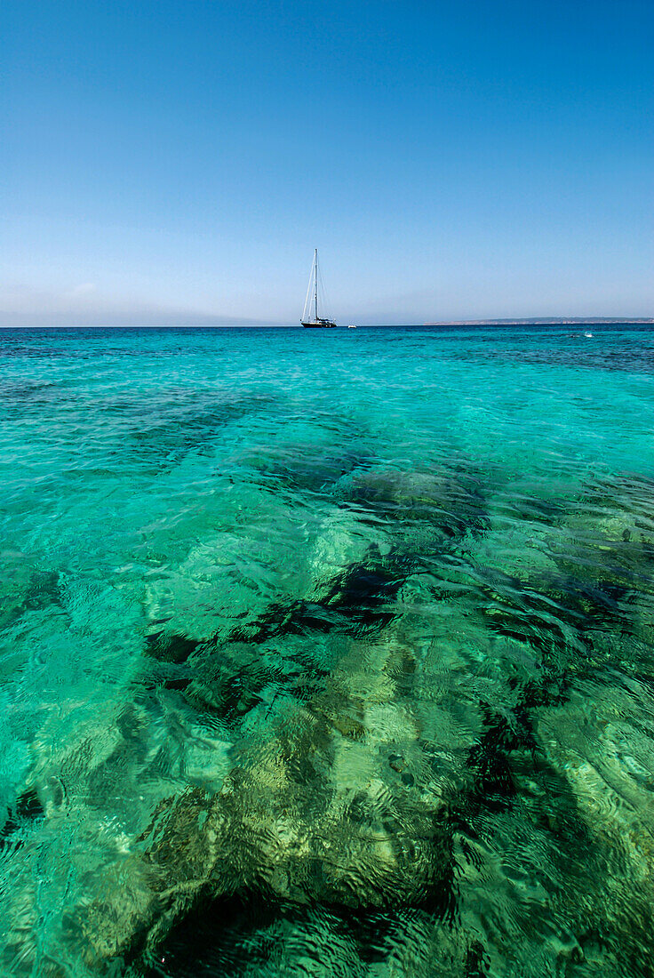 Segelboot in den klaren Gewässern von Mitjorn, Formentera