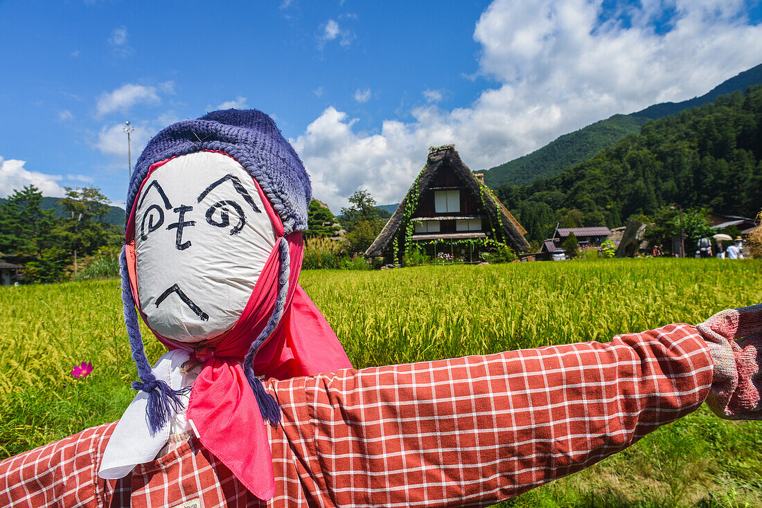 Scarecrows in front of traditional Gassho-Zukuri thatched wooden farmhouses in Shirakawa-go village, Gifu Prefecture, Japan