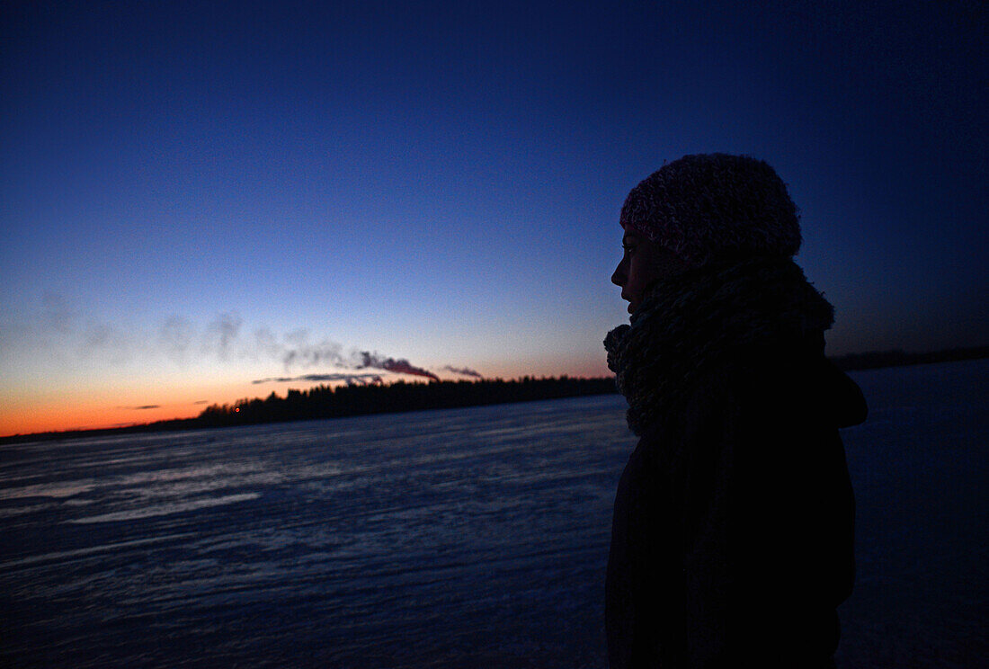 Junge Frau beim Spaziergang auf dem zugefrorenen Wasser des Bottnischen Meerbusens, Kemi, Lappland