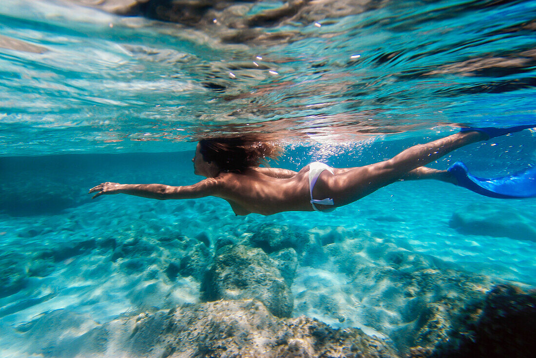 Woman underwater in Mitjorn beach in Formentera, Spain