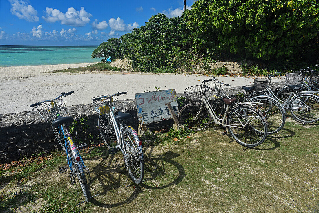 Abgestellte Fahrräder am Strand von Kondoi, Insel Taketomi, Präfektur Okinawa, Japan