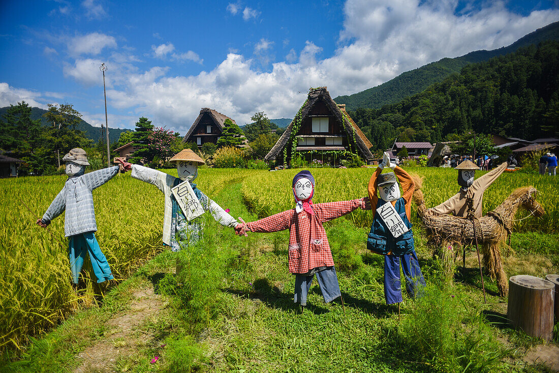 Scarecrows in front of traditional Gassho-Zukuri thatched wooden farmhouses in Shirakawa-go village, Gifu Prefecture, Japan