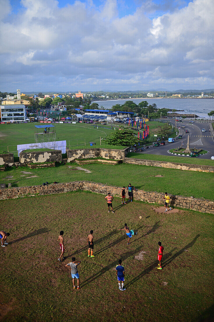 Straßenfußballspiel auf einem improvisierten Feld neben dem UNESCO-Weltkulturerbe Galle Fort, während des Binara-Vollmond-Poya-Tages