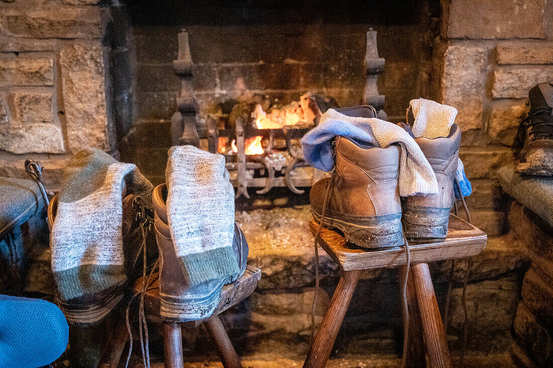 Wanderschuhe werden vor einem Feuer getrocknet