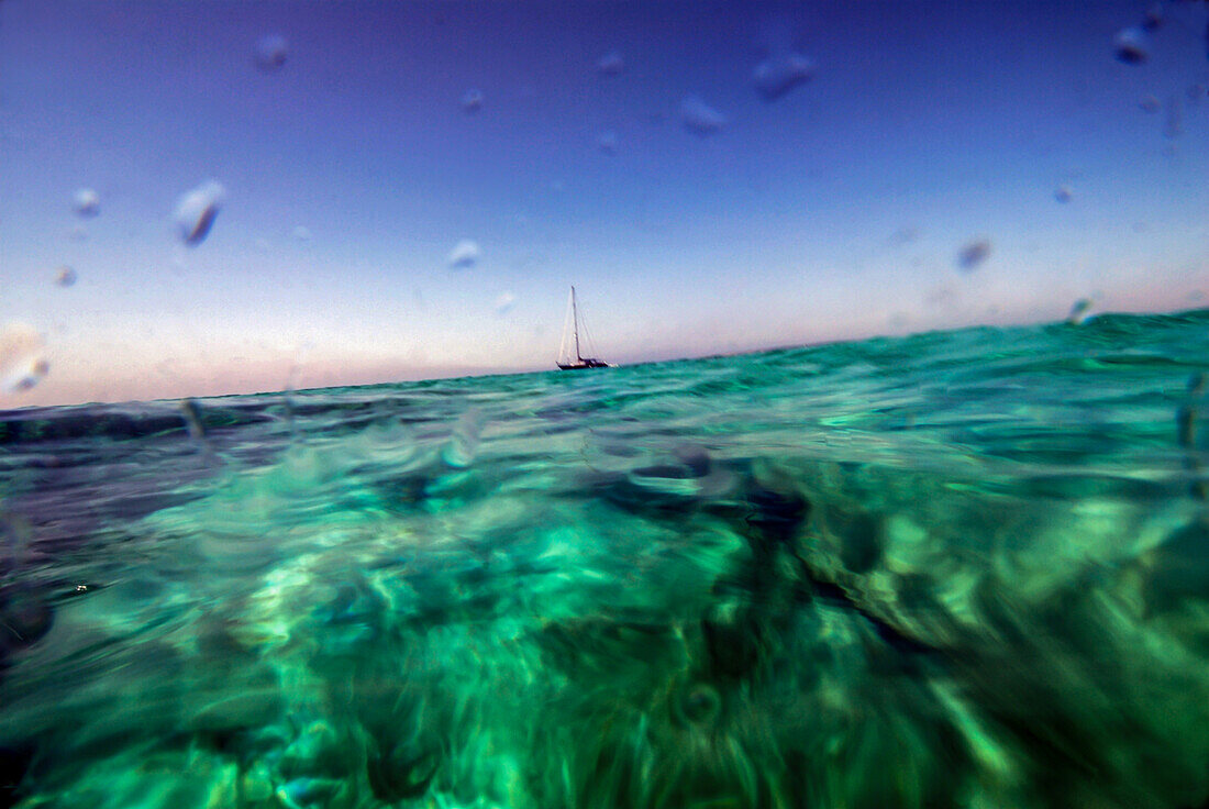 Sailing boat in the clear waters of Mitjorn, Formentera.