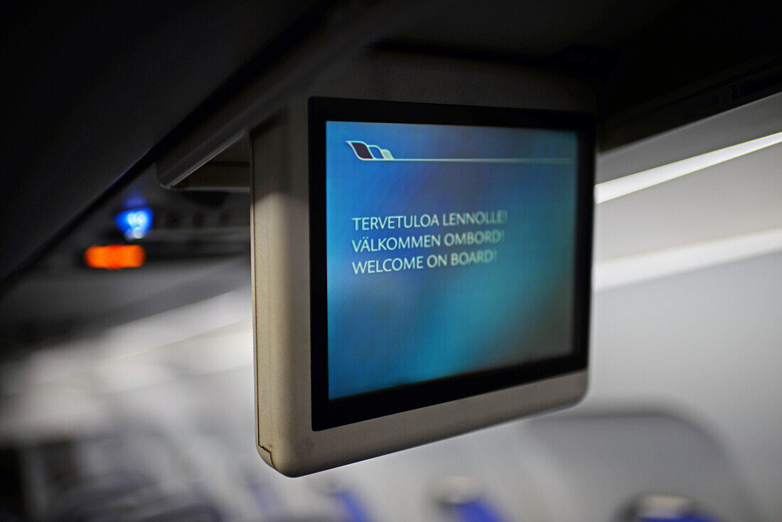 Bildschirm im Flugzeug zeigt "Willkommen an Bord" auf Englisch und Finnisch