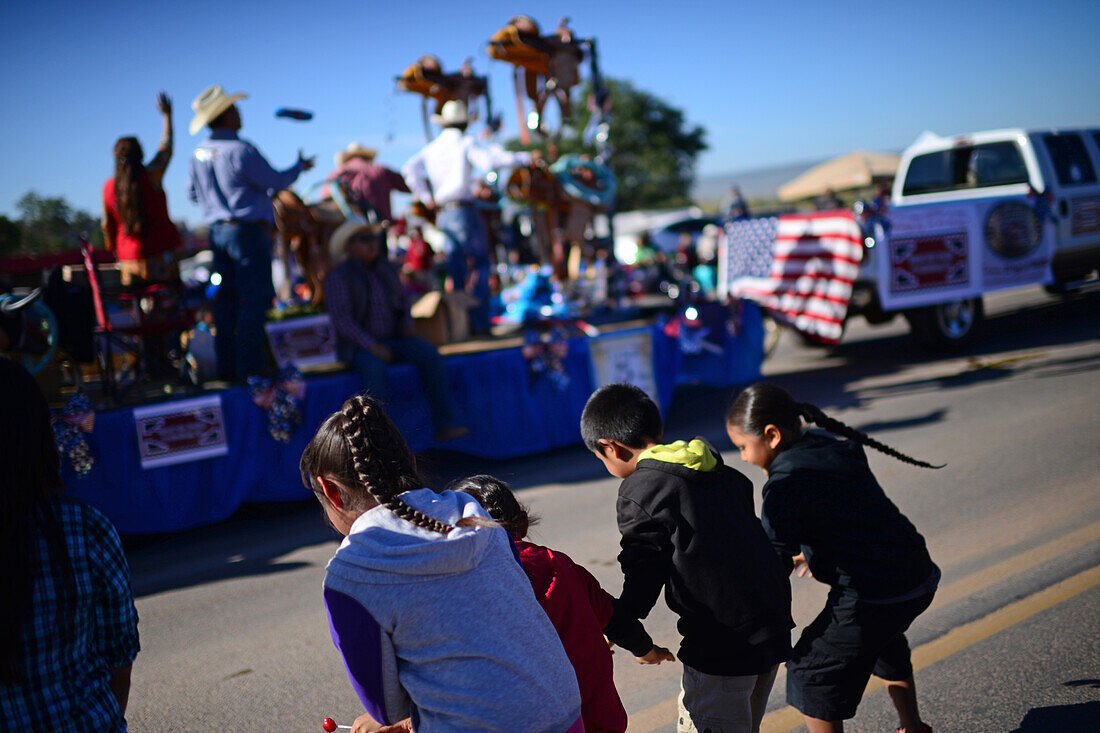 Kids wait and catch candies during morning parade at Navajo Nation Fair, a world-renowned event that showcases Navajo Agriculture, Fine Arts and Crafts, with the promotion and preservation of the Navajo heritage by providing cultural entertainment. Window Rock, Arizona.
