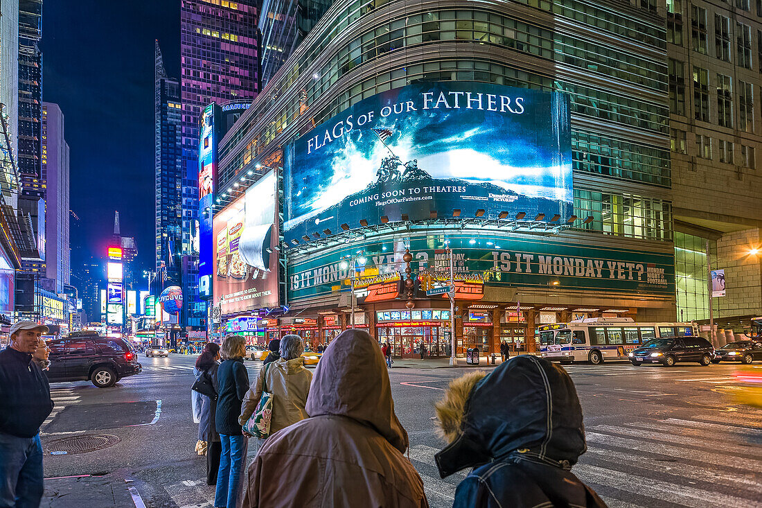 Menschen auf dem Times Square bei Nacht, NYC. Eine große Werbetafel für den Film "Flags of our fathers" (von Clint Eastwood) ist zu sehen