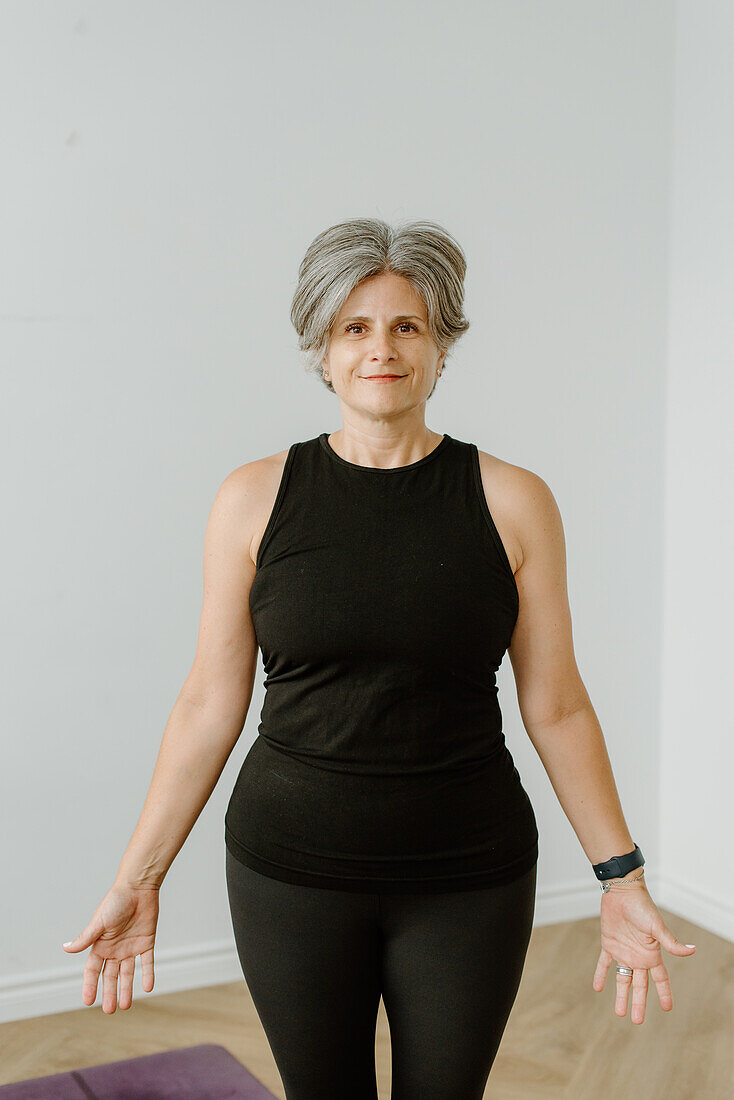 Portrait of smiling woman standing in Tadasana pose