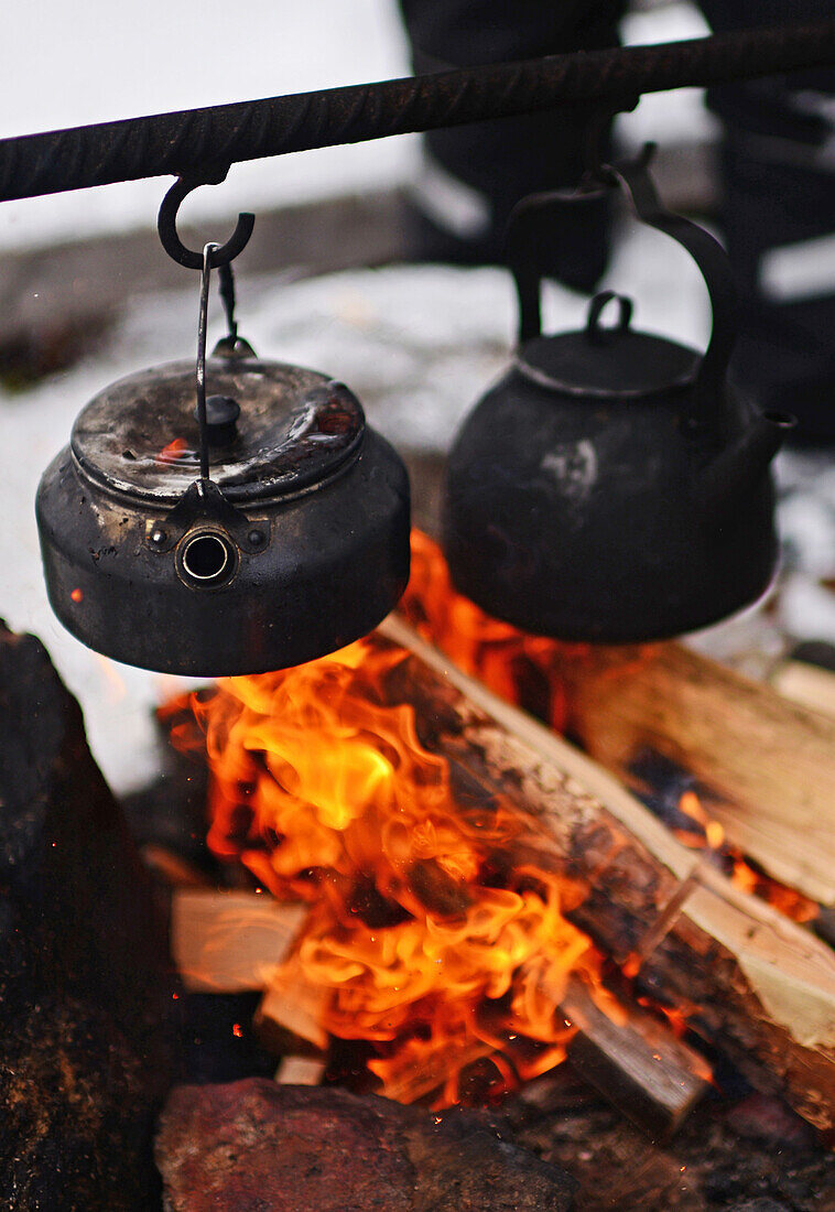 Preparing coffee and tea on the fire at Lake Inari, Lapland, Finland