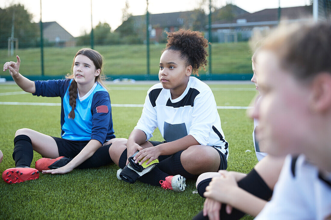 UK, Frauenfußballmannschaft (10-11, 12-13) sitzt während des Trainings auf dem Feld
