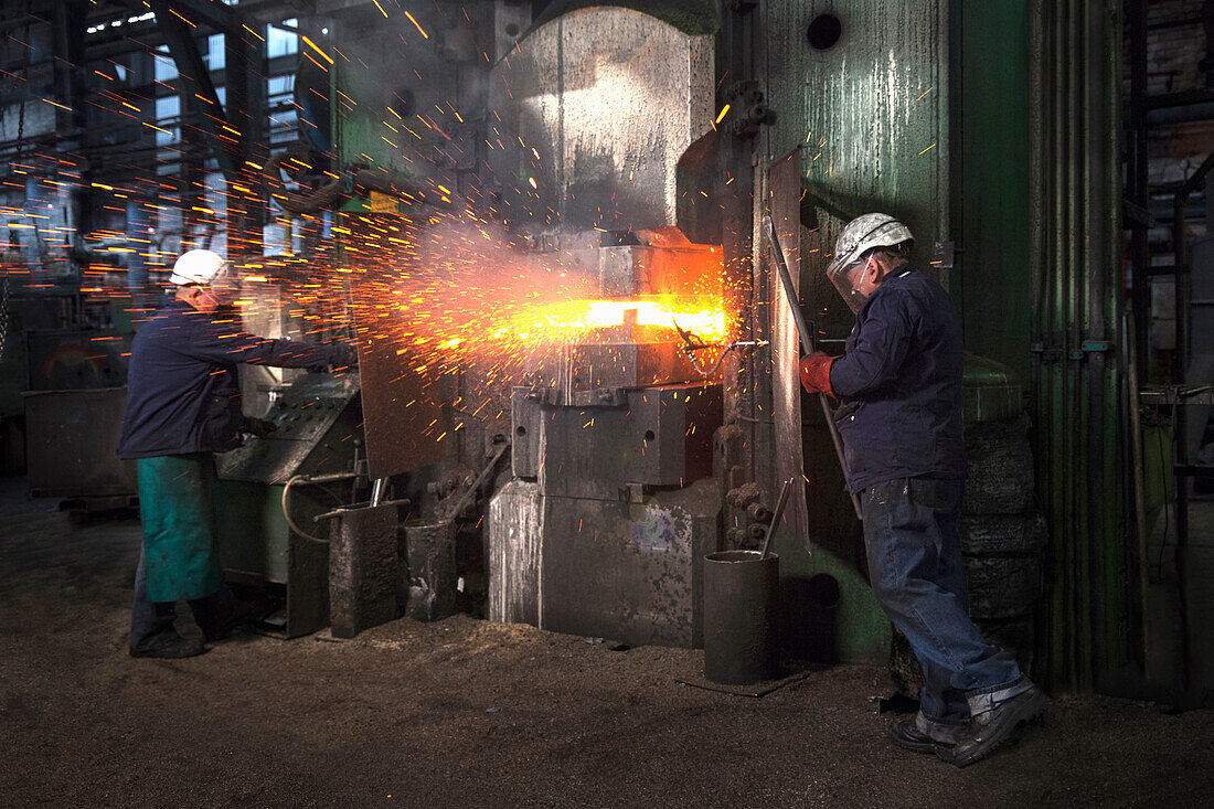 Sparks fly as counterblow hammer forms flight bar, the counterblow hammer forges by striking from both above and below mining component